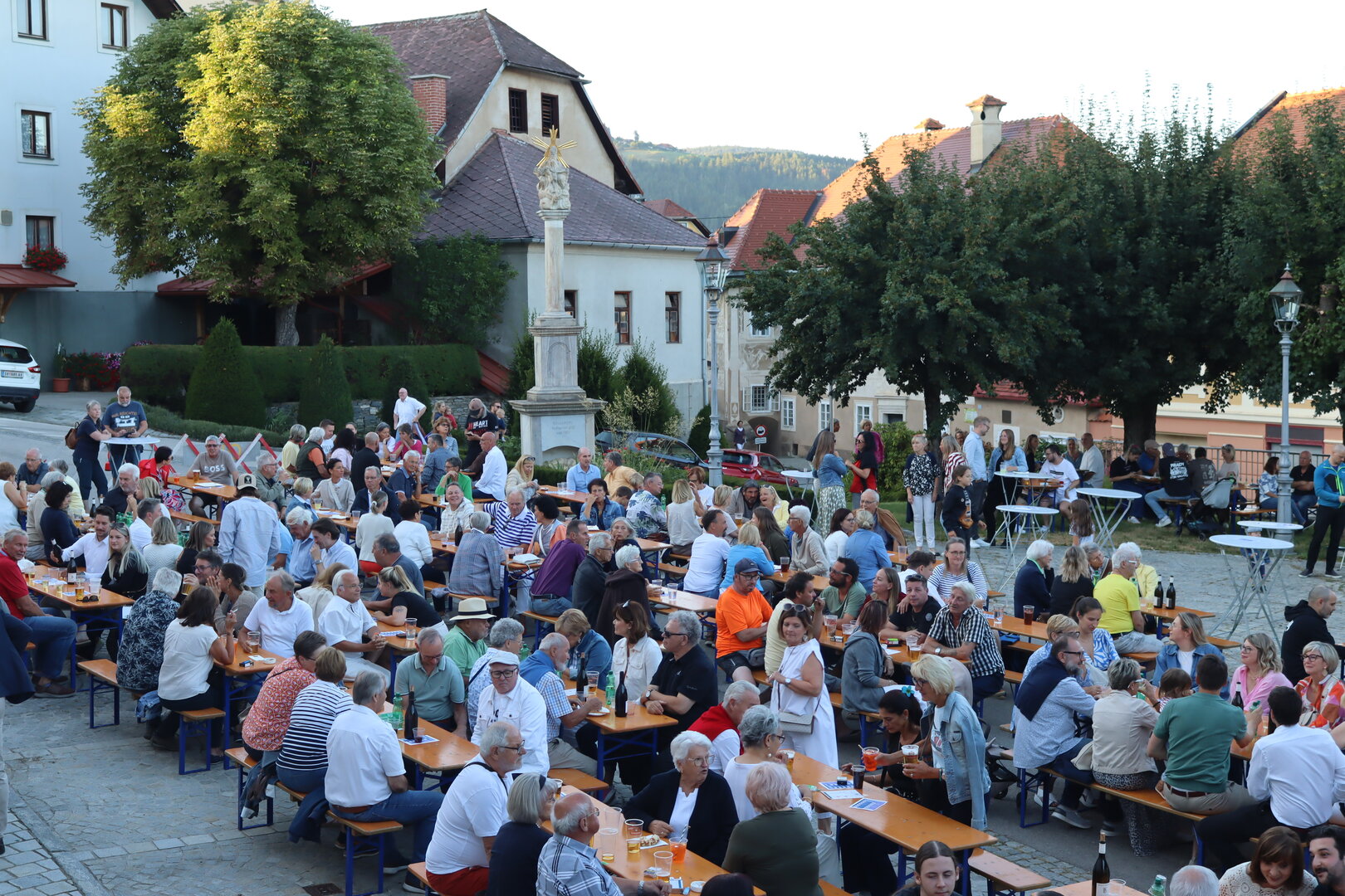 Fest in Krems: Viele Menschen sitzen an langen Tischen und feiern auf dem Platz.